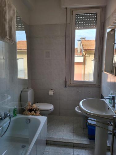 a bathroom with a tub and a toilet and a sink at A due passi dal mare Lovely Apartment Viareggio in Viareggio