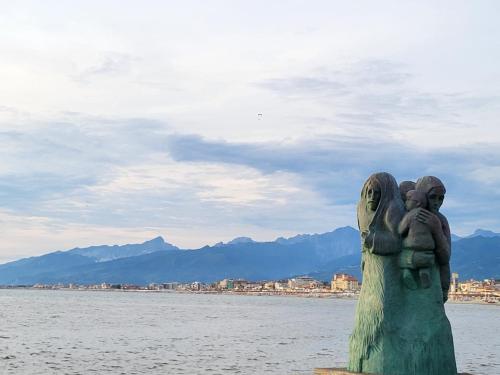 a statue of a woman holding two children on the water at A due passi dal mare Lovely Apartment Viareggio in Viareggio