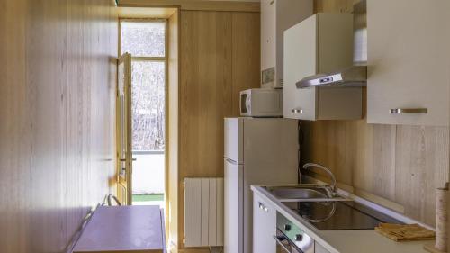 a kitchen with a white refrigerator and a window at Bellagio, Como Lake Breva - Como Lake in Bellagio