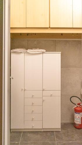 two white cabinets in a kitchen with a bucket at Bellagio, Como Lake Breva - Como Lake in Bellagio