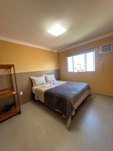 a bedroom with a large bed with a window at Aconchego e paz no Centro de Vila Velha in Vila Velha