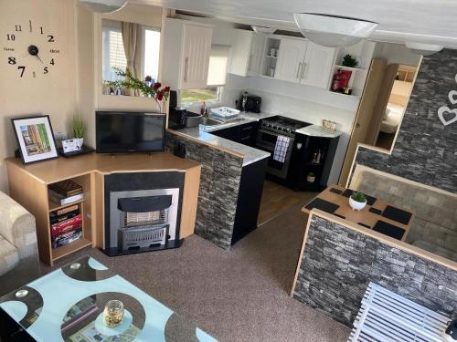 a large living room with a kitchen and a living room at Cosy 8 Berth Caravan At California Cliffs With Decking And Wifi Ref 50036H in Great Yarmouth