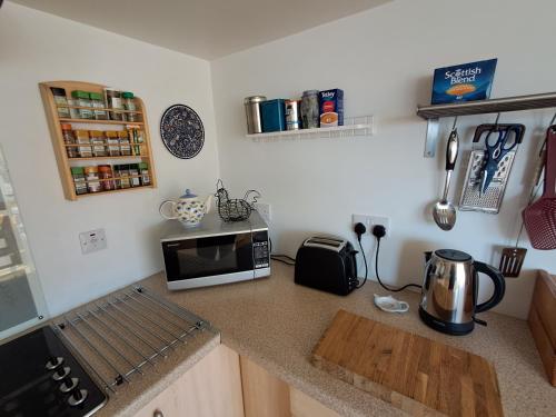 a kitchen with a counter top with a microwave on it at Taigh Nandag in Valtos
