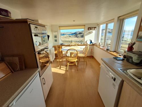 a kitchen and dining room with a table and chairs at Taigh Nandag in Valtos