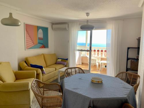 a living room with a couch and a table and chairs at Cabo Cervera Sea View in Torrevieja