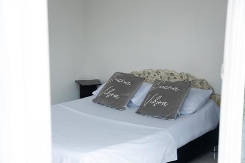 a bed with two pillows on top of it at APARTAMENTO CAMPESTRE EN EJE CAFETERO in Manizales