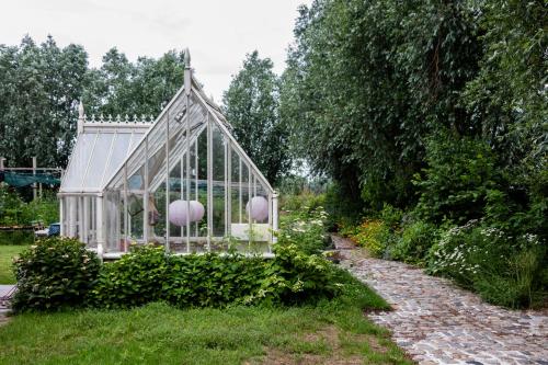 a greenhouse in the middle of a garden at De 6 Linden Boutique Hotel in Sluis