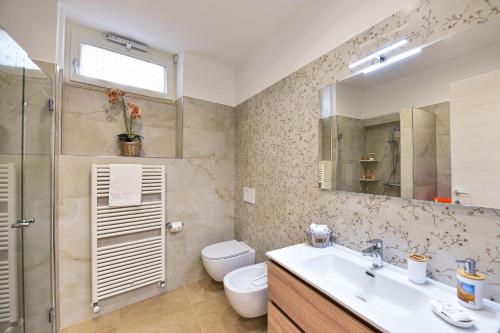a bathroom with a sink and a toilet and a mirror at La Dimora di Peppe in Locorotondo