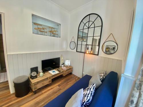 a living room with a blue couch and a tv at Flat Graça 48 in Lisbon