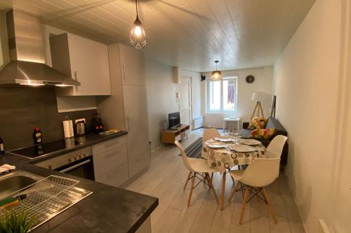 une cuisine et une salle à manger avec une table et des chaises dans l'établissement Ch3-0 Les cosy Nancy by Rock in Share, à Nancy