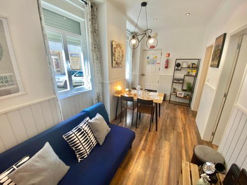 a living room with a blue couch and a table at Flat Graça 48 in Lisbon