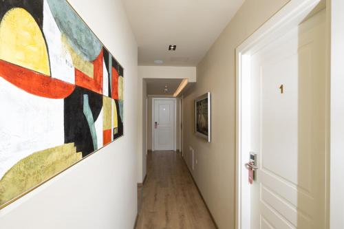 a hallway with a large painting on the wall at 4R Colombo Hotel in Tirana