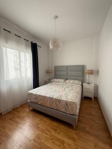 a bedroom with a bed and a pendant light at Ole Jerez! in Jerez de la Frontera