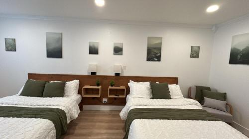 two beds in a room with pictures on the wall at Hygge Hus Hotel in Andrews