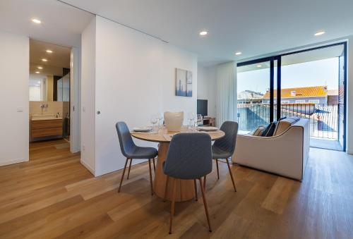 a dining room with a table and some chairs at Tiles 23 Luxury Apartment & Parking by Home Sweet Home Aveiro in Aveiro