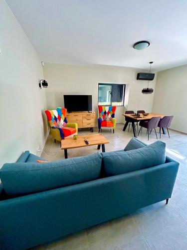 a living room with a blue couch and a tv at Casa Helena in Tavira