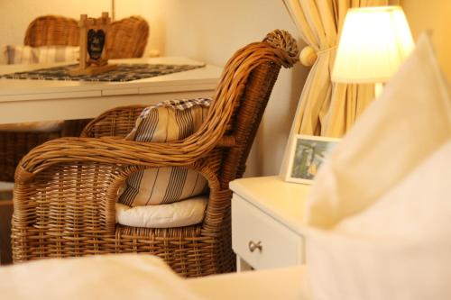 a bedroom with a wicker chair and a table at Strandkojen in Trassenheide