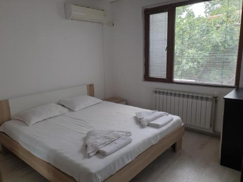 a bedroom with a bed with two towels on it at Apartament Magi in Sozopol