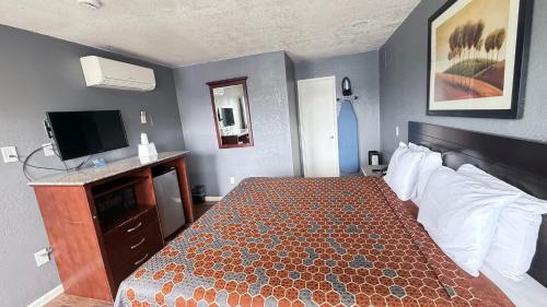 a hotel room with a bed and a television at Fireside Inn By The Beach Boardwalk & Bowling in Santa Cruz
