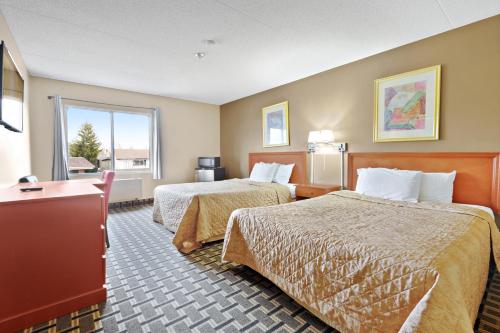 a hotel room with two beds and a window at Niagara Lodge & Suites in Niagara Falls