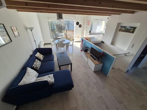 a living room with a blue couch and a table at Clem, coquette maison, wifi, jardin, parking, barbecue in La Rochelle