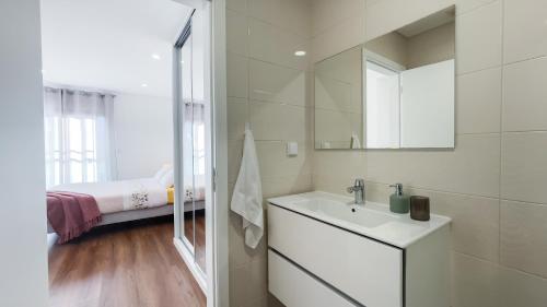 a white bathroom with a sink and a mirror at Nico Home in Ponta Delgada