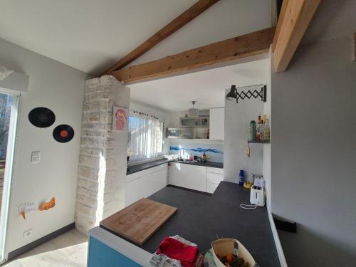 une cuisine avec des armoires blanches et un comptoir dans l'établissement Clem, coquette maison, wifi, jardin, parking, barbecue, à La Rochelle