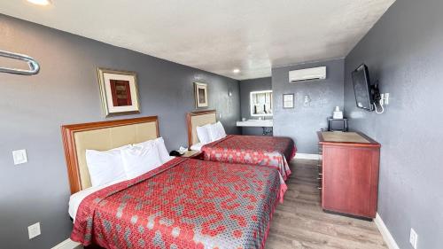 a hotel room with two beds and a television at Fireside Inn By The Beach Boardwalk & Bowling in Santa Cruz