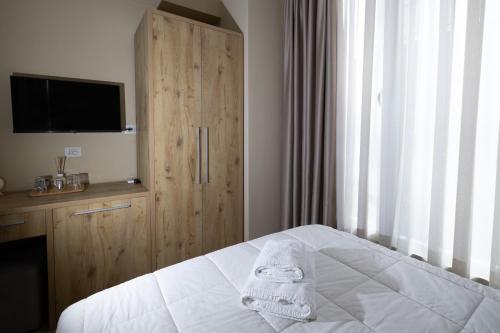a bedroom with a bed and a wooden cabinet at 4R Colombo Hotel in Tirana