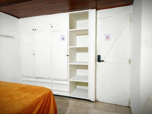 a bedroom with white closets and a bed at Ayllu Hostel in Bogotá