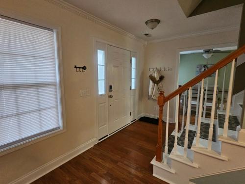 a hallway with a staircase and a large window at Spacious 3 BR Retreat in Leland in Leland