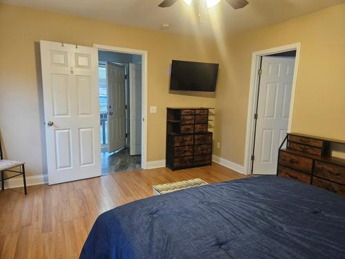 a bedroom with a bed and a tv on the wall at Spacious 3 BR Retreat in Leland in Leland