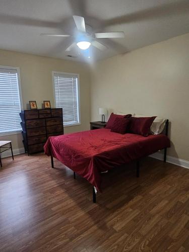 a bedroom with a bed with a red comforter at Spacious 3 BR Retreat in Leland in Leland