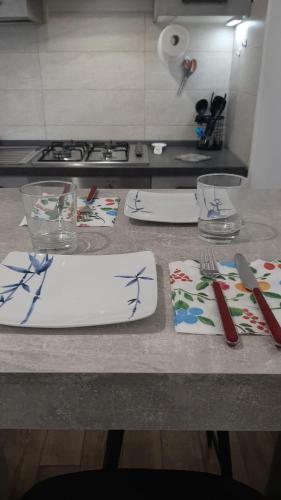 a kitchen counter with plates and utensils on it at Apartment A&D Home Imola Centro in Imola