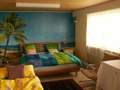 a bedroom with a bed and a palm tree mural at Villa Lavendel in Gondiswil