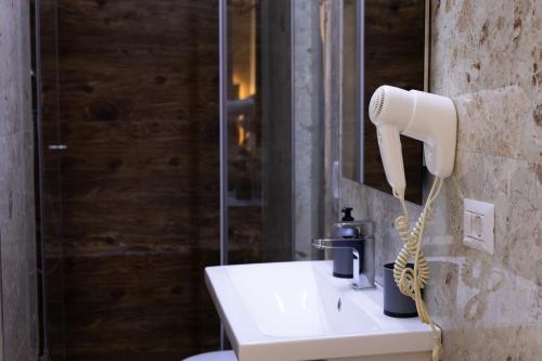 a bathroom with a white blow dryer on a sink at 4R Colombo Hotel in Tirana