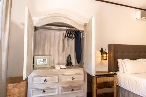 a bedroom with a dresser next to a bed at Casa de Adobe Gallery & Luxury Boutique in Oaxaca City