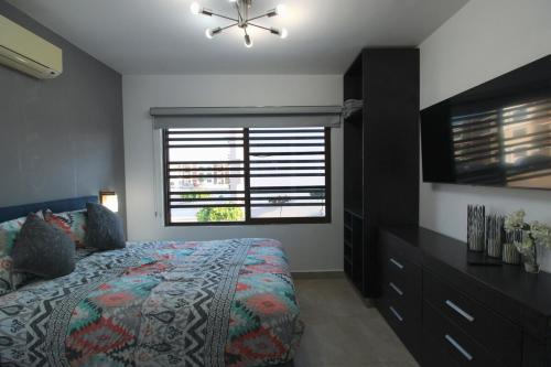 een slaapkamer met een bed, een ladekast en een raam bij Departamento Close to Beach - Azul pacifico in Mazatlán