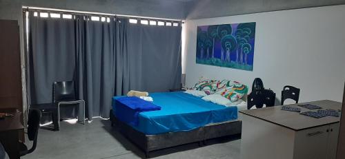 a bedroom with a blue bed and a desk at Medellín Apartment Loft in Medellín