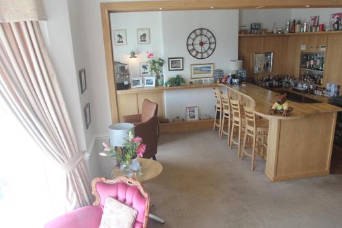 a living room with a bar and a table and chairs at Bryn-Y-Mor Hotel in Llandudno