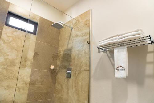 a bathroom with a shower with a glass door at Casa de Adobe Gallery & Luxury Boutique in Oaxaca City