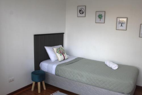 a small bedroom with a bed and a blue stool at Hab económica cerca del aeropuerto in Santiago