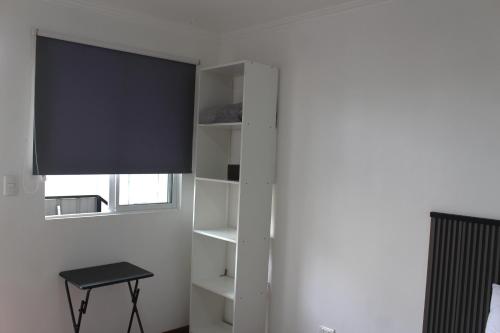 a living room with a tv and a shelf at Hab económica cerca del aeropuerto in Santiago