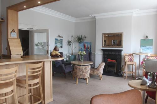 a living room with a bar and a fireplace at Bryn-Y-Mor (ADULT ONLY) in Llandudno
