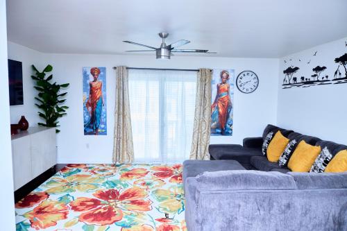 a living room with a couch and a clock at Beautifully Designed & Spacious Apartment in Newark 10mins from EWR Airport, Close to NYC and Beth Israel Hospital in Newark