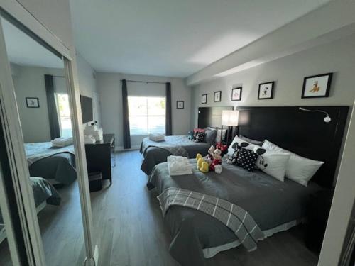 a bedroom with two beds and a mirror at Disney 1st floorEpicFREE ShuttlePARKINGNO FEES in Orlando