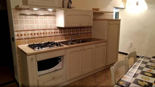 a kitchen with a sink and a stove top oven at AgriIlGeco IV - Casa Clementi - by HOST4U in Civezza