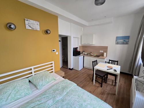 une chambre avec un lit et une table et une cuisine dans l'établissement E1 - Charmant studio en intramuros, rénové climatisé, à Avignon