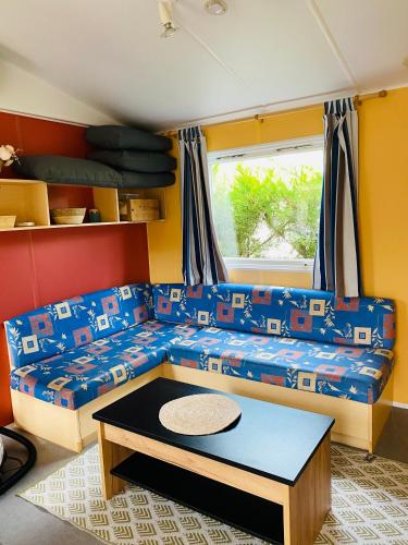 un salon avec un canapé et une table dans l'établissement Mobilhome Harmonie, à Biscarrosse