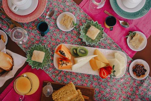 a table topped with plates of cheese and bread at Pousada Meu Talento in Alto Paraíso de Goiás